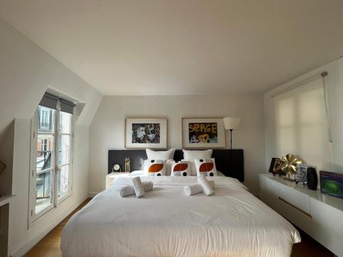- une chambre avec un grand lit blanc et des oreillers blancs dans l'établissement Pompidou, rue Simon le Franc - 4 places, à Paris