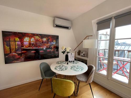 une table et des chaises dans une pièce ornée d'un tableau mural dans l'établissement Pompidou, rue Simon le Franc - 4 places, à Paris