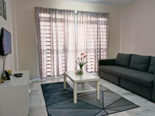 a living room with a couch and a table at Sweet Homestay in Port Dickson