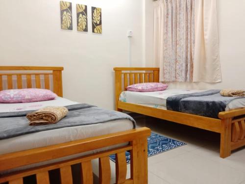 dos camas sentadas una al lado de la otra en una habitación en Sweet Homestay, en Port Dickson