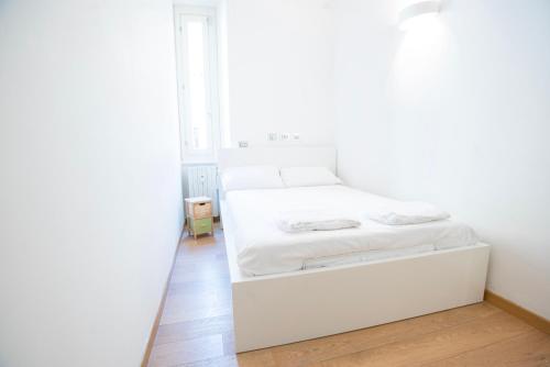 ein weißes Schlafzimmer mit einem weißen Bett und einem Fenster in der Unterkunft Beautiful apartment in Sta Maria delle Grazie by Easylife in Mailand