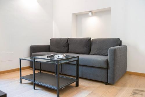 ein Wohnzimmer mit einem Sofa und einem Tisch in der Unterkunft Beautiful apartment in Sta Maria delle Grazie by Easylife in Mailand