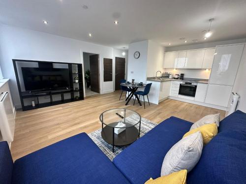 sala de estar con sofá azul y cocina en 1 Bed Apartment near Old Trafford with free car park, en Mánchester