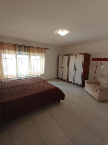 a bedroom with a bed and a couch and a chair at Maison G in LʼAquila