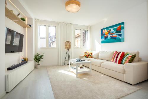 uma sala de estar branca com um sofá e uma televisão em Rubini - modern apartment in the heart of old Rovinj em Rovinj