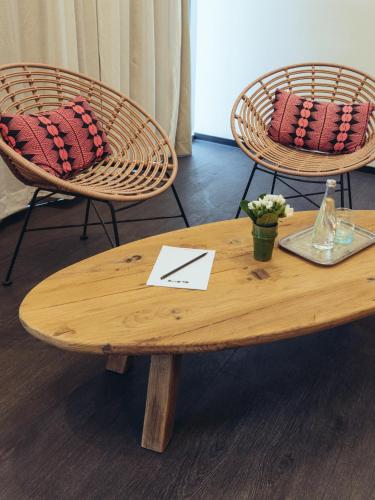 a wooden coffee table with two chairs and a table with aoice at ONOMO Airport Casablanca in Casablanca