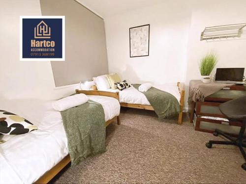 1 dormitorio con 2 camas y escritorio con ordenador en Botany House - Company & Family Stays en Bescot