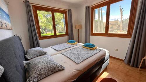 um quarto com uma cama com duas almofadas em Finca Can Bagur Ventolra em Biniali