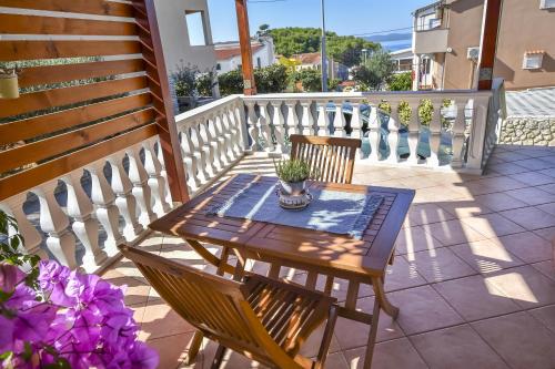 a wooden table and chairs on a balcony at Apartment Burin in Drage