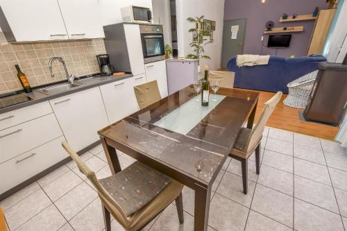 a kitchen with a table and chairs in a kitchen at Apartment Burin in Drage