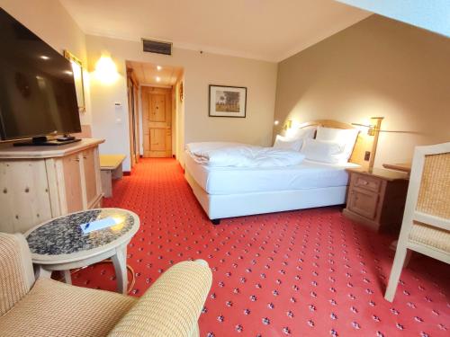 a hotel room with two beds and a television at Atomis Hotel Munich Airport by Mercure in Oberding