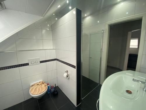 ein Badezimmer mit einem Waschbecken, einem WC und einem Spiegel in der Unterkunft Ferienwohnung Sabine in Annweiler am Trifels