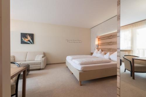 a hotel room with a bed and a couch at Hotel Olympia in Obergurgl