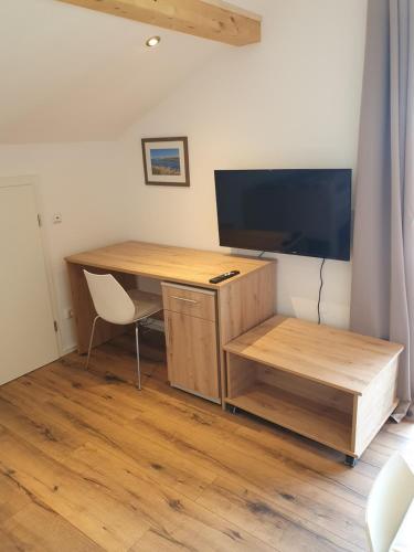 a desk with a television and a desk with a chair at FeWo Rotter Blick in Rott am Inn