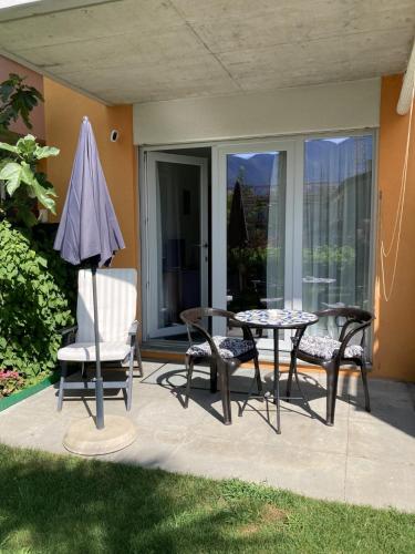 a patio with a table and chairs and an umbrella at Tarta-Loft in Minusio