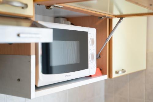 a microwave oven on a shelf in a kitchen at Residence Millennium in Rimini