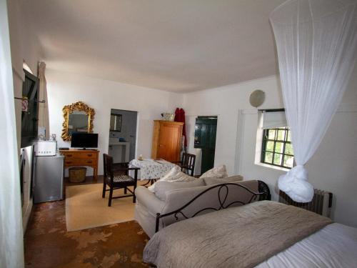 a bedroom with a bed and a living room at EpiStay in Tulbagh