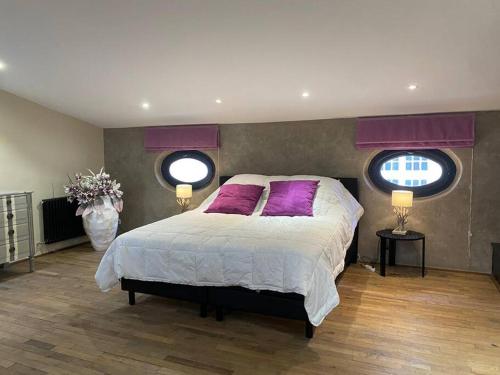 - une chambre avec un lit doté d'oreillers violets et 2 fenêtres dans l'établissement Le Grand Mazarin T2, à Aix-en-Provence
