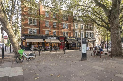 a bike parked on a sidewalk in front of a building at Sun drenched 1 bedroom apartment in Farringdon in London