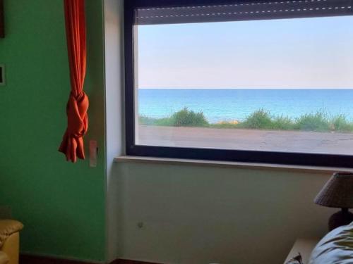 um quarto com uma janela com vista para o oceano em Appartamento fronte mare in via fiume em Gallipoli