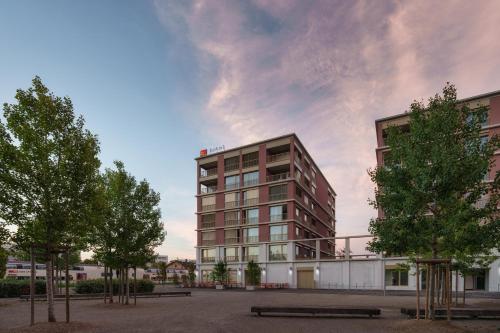 una rappresentazione di un edificio con alberi di fronte ad esso di b-smart hotel Arbon ad Arbon