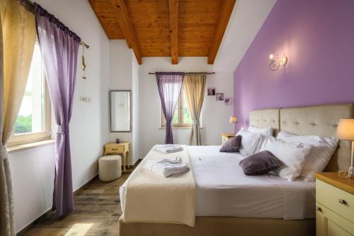 1 dormitorio con paredes moradas y 1 cama grande en Villa Stella Polaris, en Štuti