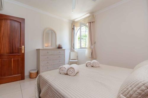 - une chambre blanche avec un lit et des serviettes dans l'établissement Villa Vista Gomera, à Puerto de Santiago