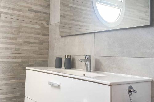 La salle de bains est pourvue d'un lavabo blanc et d'une fenêtre. dans l'établissement Villa Vista Gomera, à Puerto de Santiago