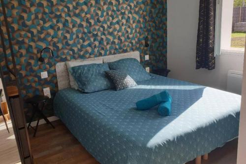 uma cama com lençóis azuis e sapatos azuis em joli appartement classé 4 étoiles em Saint-Georges-dʼOléron