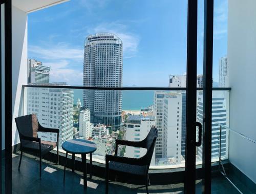 a balcony with chairs and a table and a view of a city at Virgo Hotel Nha Trang in Nha Trang