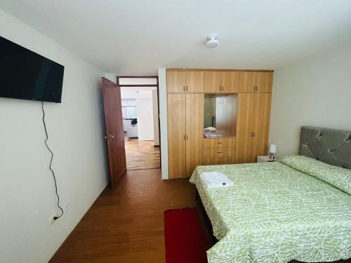 a bedroom with a bed and a flat screen tv at Villa Salluzzi Apart Hotel in Tacna
