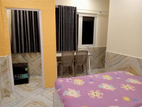 a bedroom with a bed and a table and chairs at An Chi Hotel in Ho Chi Minh City