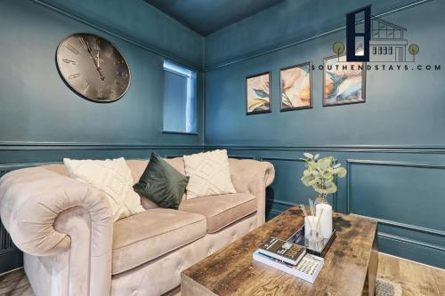 uma sala de estar com um sofá e um relógio na parede em Urban Lux - Modern One-Bedroom Flat in Southend-On-Sea - Southend Stays em Southend-on-Sea