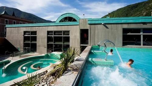 a man is in a swimming pool in a house at Appartement - Ax les Thermes in Ax-les-Thermes