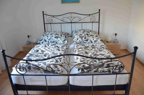 uma cama com uma armação de metal e almofadas em Haus Blütenzauber em Sipplingen