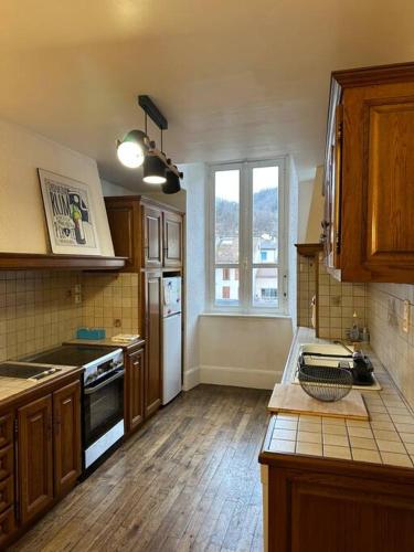 a kitchen with wooden cabinets and a counter top at Appartement - Ax les Thermes in Ax-les-Thermes