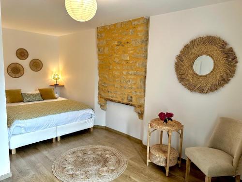 a bedroom with a bed and a chair and a mirror at Sweet Omaha in Colleville-sur-Mer