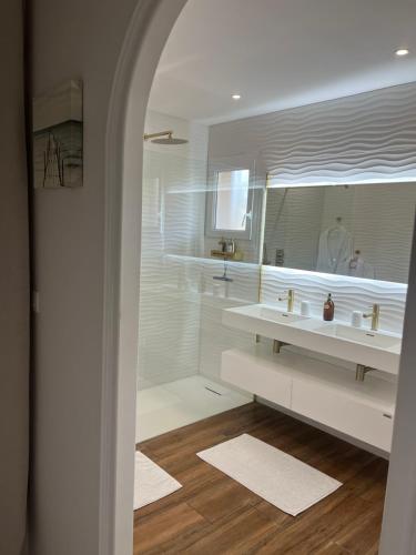 a bathroom with two sinks and a large mirror at Chambres d'Hôtes Villa La Louisiane in Arès