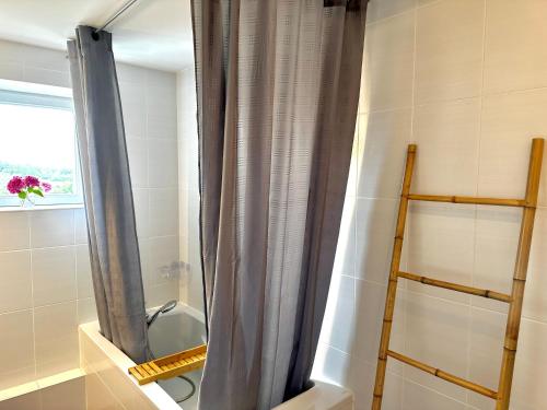 a shower curtain in a bathroom with a toilet at Sweet Omaha in Colleville-sur-Mer