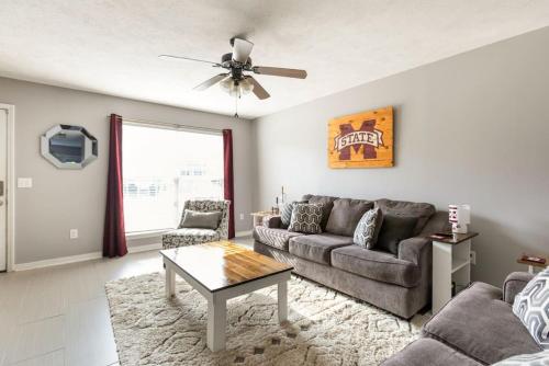 a living room with a couch and a table at Bulldog Academy. Convenient to MSU. in Starkville