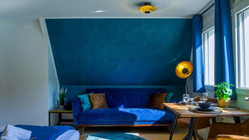 - un salon bleu avec un canapé et une table dans l'établissement Ruhig, Zentral & Modern im Herzen Ulms, à Ulm
