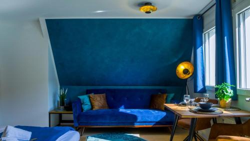 a blue living room with a couch and a table at Ruhig, Zentral & Modern im Herzen Ulms in Ulm