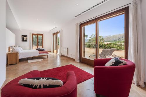 a living room with red chairs and a large window at Villa Coloma in El Port