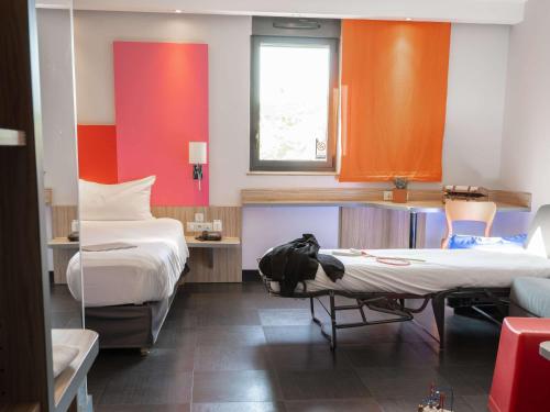 Habitación con 2 camas, mesa y sillas en ibis Styles Romans-Valence Gare TGV, en Alixan