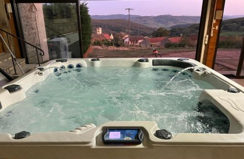 a jacuzzi tub with a clock in it at Domaine-Bayard in Bergesserin