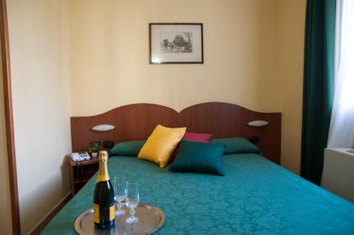 a bedroom with a bed with a bottle of wine on a table at The Best Hotel in Milan