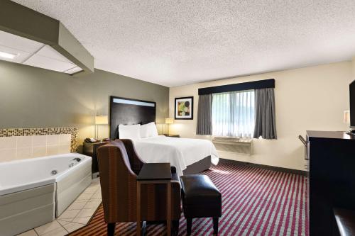a hotel room with a bed and a bath tub at Best Western Germantown Inn in Germantown