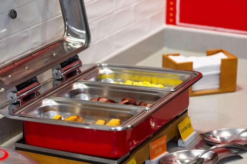 a food cart with trays of food on a counter at Hampton Inn Medford in Medford