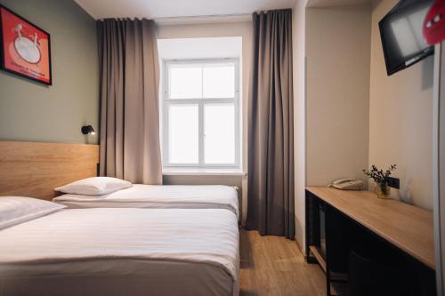 a hotel room with two beds and a window at Rija Old Town Hotel in Tallinn