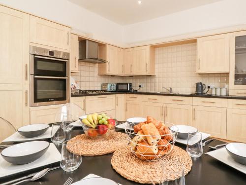 a kitchen with a table with a basket of fruit on it at Church View in Grange Over Sands